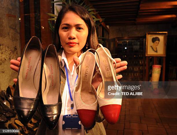 Museum employee shows two pairs of the hundreds of shoes of former Philippine first lady Imelda Marcos, at the shoe museum in Manila on September 26,...