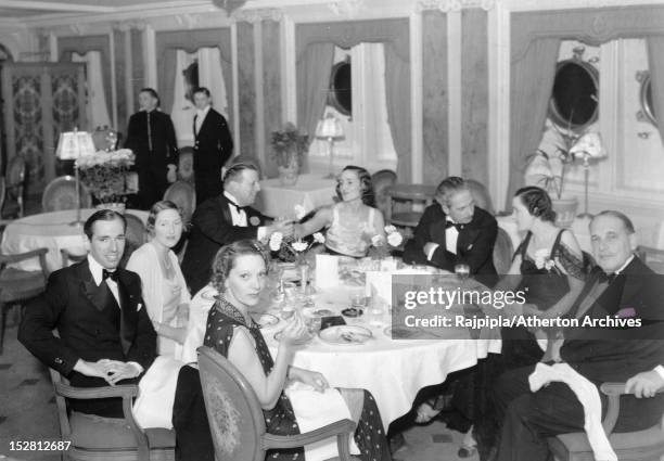 English actress and singer Gertrude Lawrence and her dining companions on board the RMS Queen Mary, March 1939. Clockwise, from Lawrence: script and...