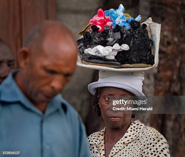 Woman sells plastic bags that will soon be banned in Haiti, in a market in downtown Port au Prince, a few days after Tropical Storm Isaac brought...