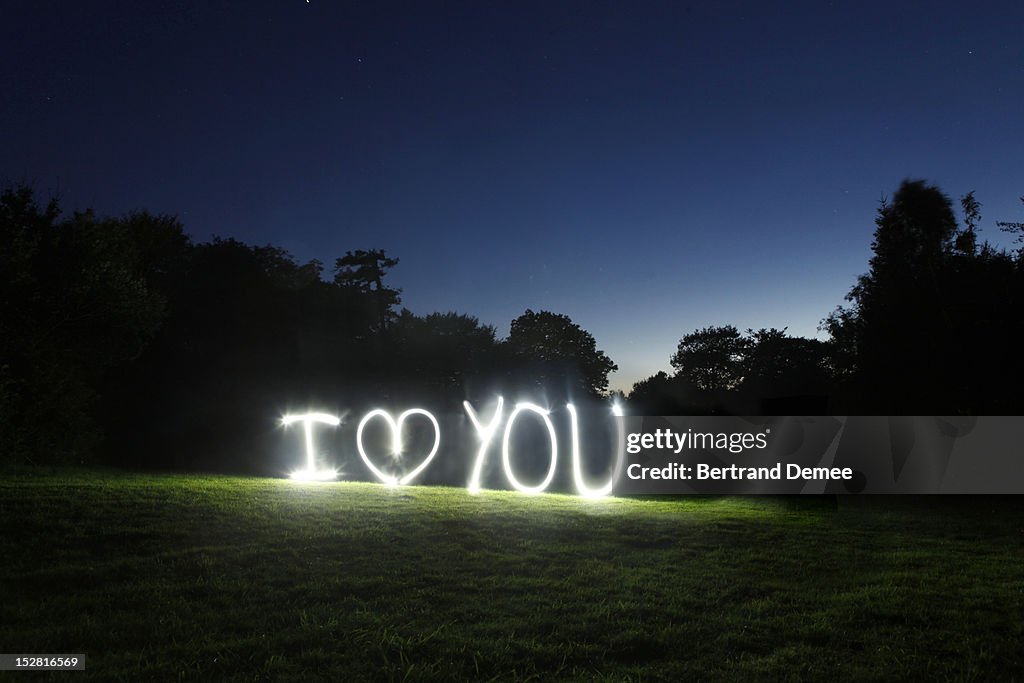 'I love you' written in light in a rural setting