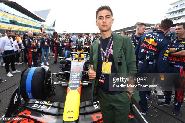 Paulo Dybala poses for a photo with the car of Max Verstappen of the Netherlands and Oracle Red Bull Racing on the grid during the F1 Grand Prix of...