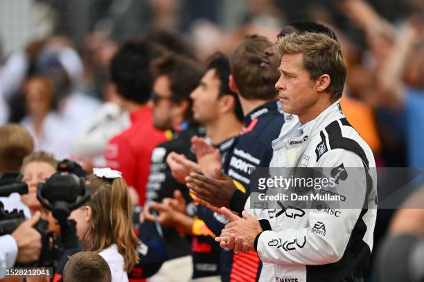 Brad Pitt, star of the upcoming Formula One based movie, Apex, stands for the national anthem on the grid during the F1 Grand Prix of Great Britain...