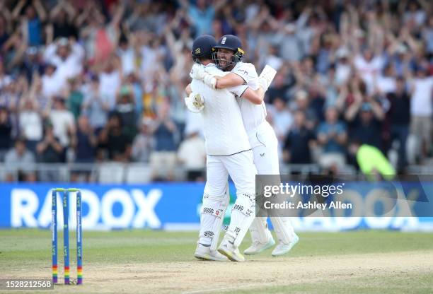 Chris Woakes of England celebrates with teammate Mark Wood after hitting the winning runs to win the LV= Insurance Ashes 3rd Test Match between...