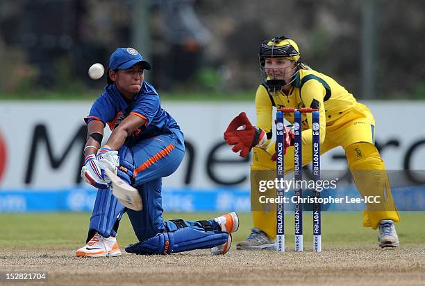 Harmanpreet Kaur of India sweeps the ball away as Jodie Fields of Australia stands by the stumps during the ICC Women's World Twenty20 Group A match...