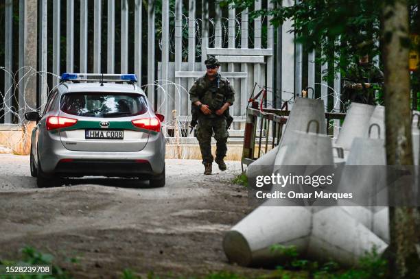 Soldier stands by anti-tank obstacles by the metal wall constructed at the Polish Belarussian border on July 08, 2023 in Bialowieza, Poland. Last...