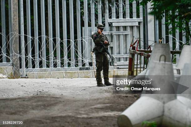 Soldier stands by anti-tank obstacles by the metal wall constructed at the Polish Belarussian border on July 08, 2023 in Bialowieza, Poland. Last...