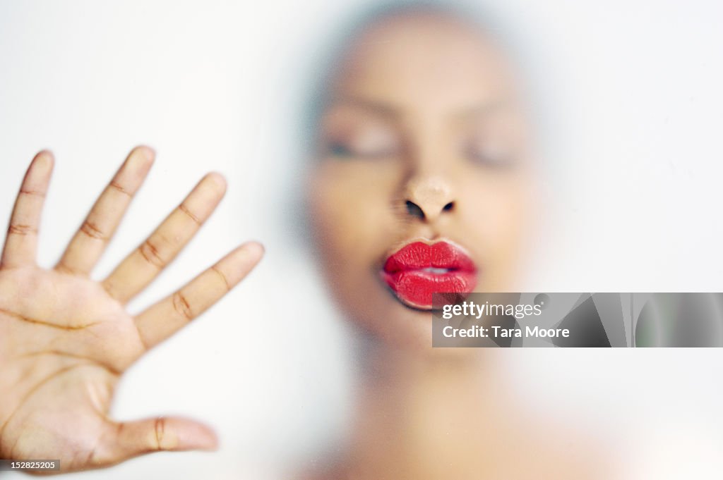 Woman kissing with face pressed against  glass
