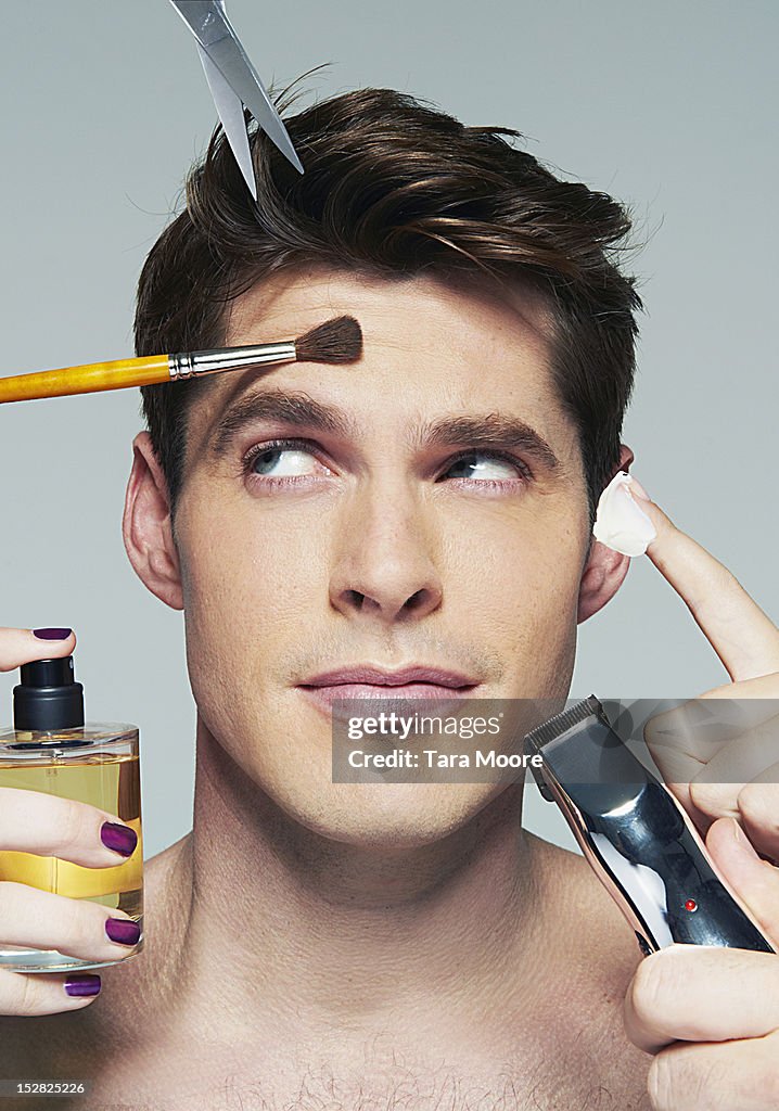 Man applying various beauty products to face