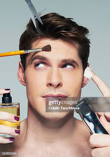 man applying various beauty products to face - 都會型男 個照片及圖片檔