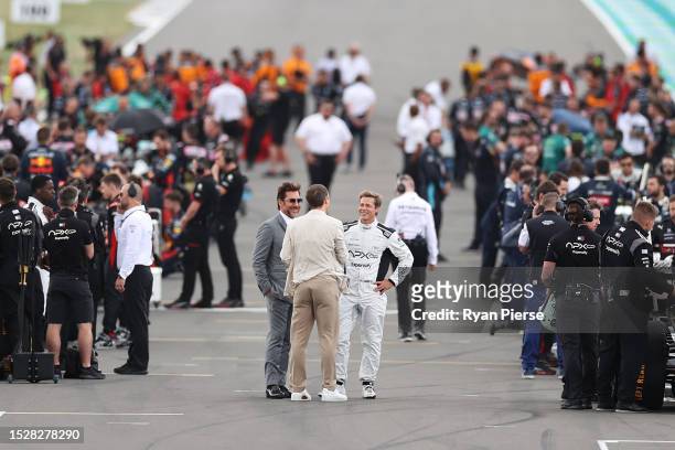 Brad Pitt, star of the upcoming Formula One based movie, Apex, and Javier Bardem talk on the grid during the F1 Grand Prix of Great Britain at...