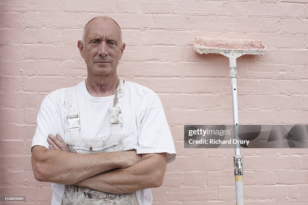 Painter standing in front of freshly painted wall