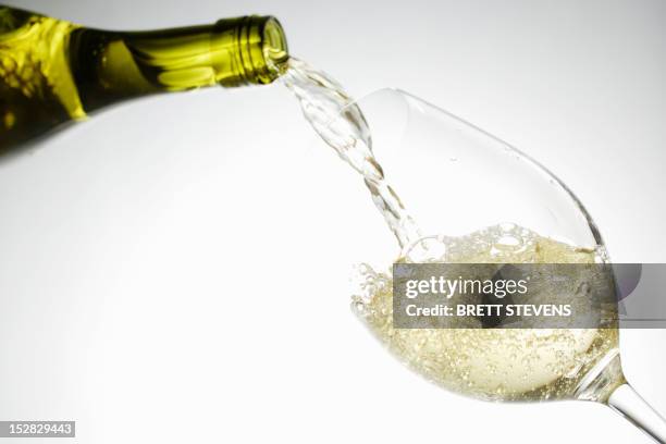 white wine pouring into glass - vin blanc photos et images de collection