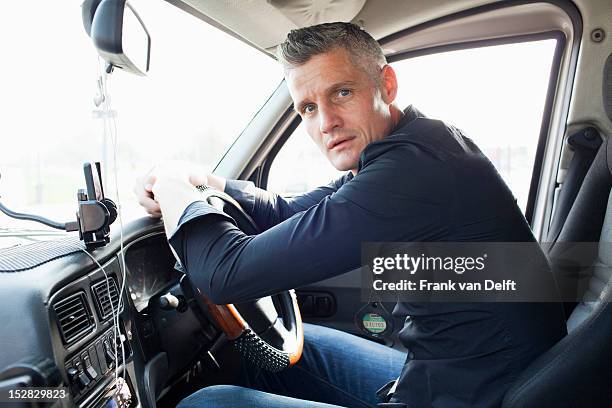 taxi driver sitting at steering wheel - taxi driver stock pictures, royalty-free photos & images