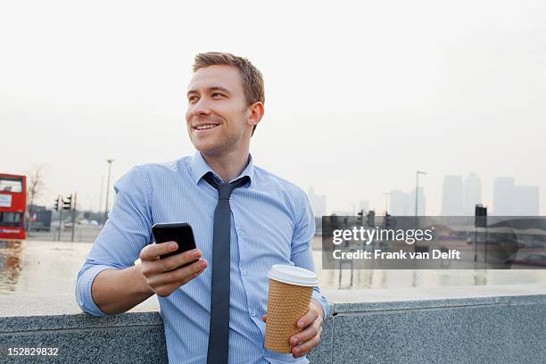 businessman using cell phone outdoors - overhemd en stropdas stockfoto's en -beelden