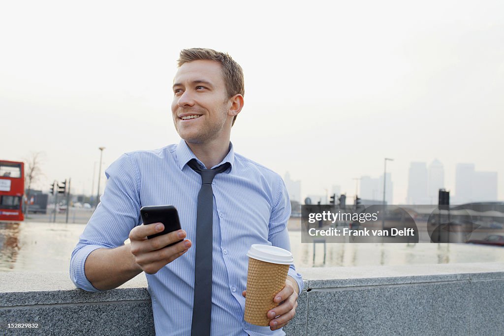 Businessman using cell phone outdoors