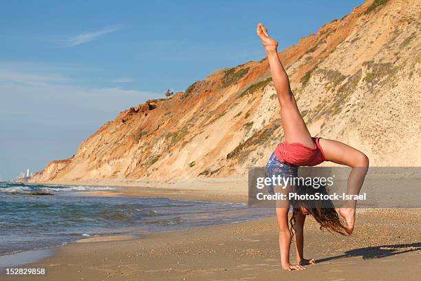 woman doing gymnastics on beach - israeli girl stockfoto's en -beelden