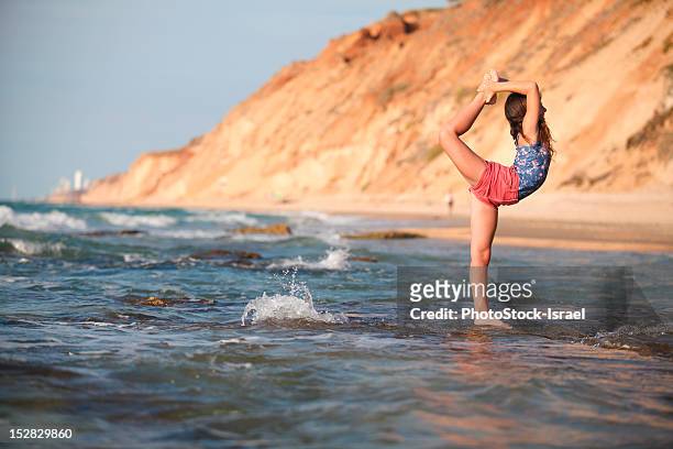 frau üben yoga am strand - adult gymnast feet stock-fotos und bilder