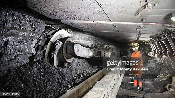 miner cutting coal at coal seem in deep mine - poço de mina imagens e fotografias de stock