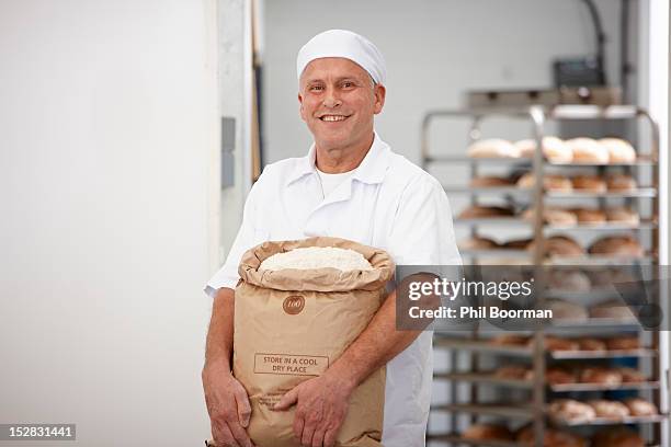 chef carrying sack of flour in kitchen - flour bag stockfoto's en -beelden