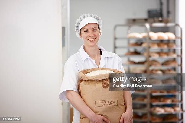 chef carrying sack of flour in kitchen - flour bag stockfoto's en -beelden