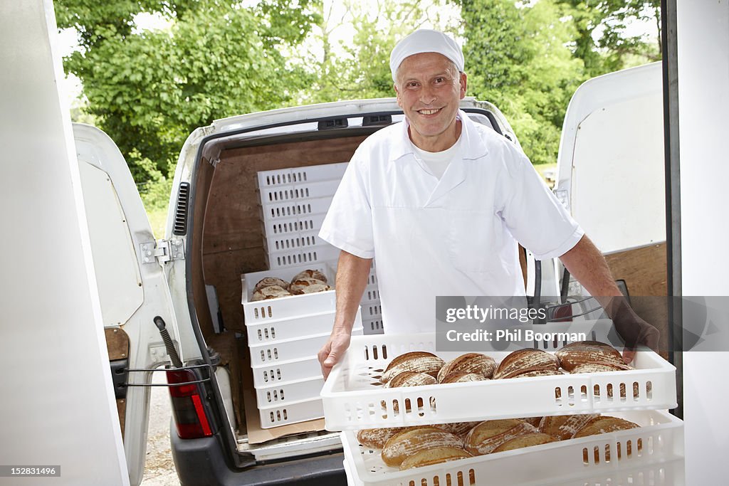 Chef carrying trays of bread to van