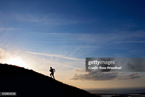 silhouette of hiker running up hillside - runner sunrise stock pictures, royalty-free photos & images