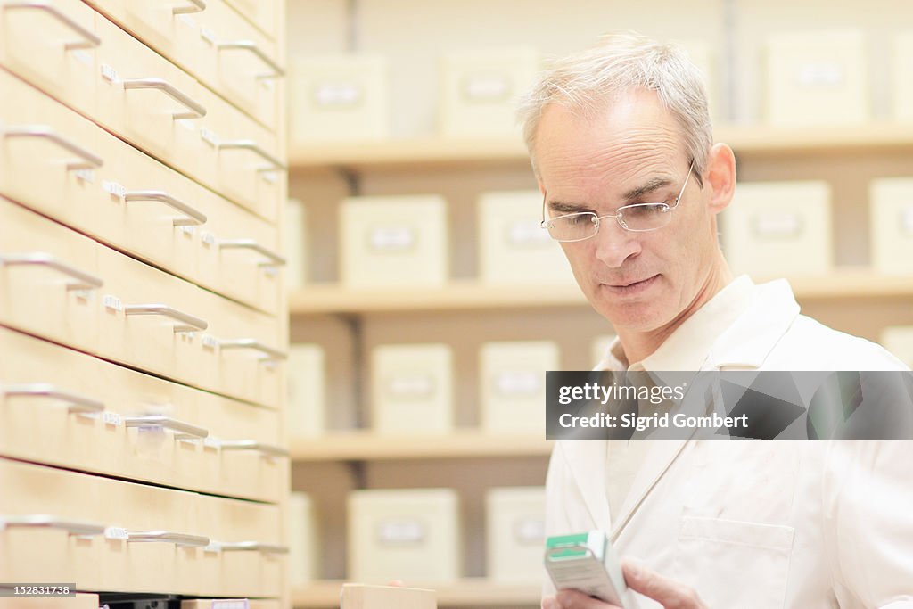 Pharmacist examining box of pills