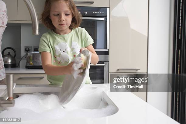 girl washing dishes in kitchen - girls taking a showering stockfoto's en -beelden