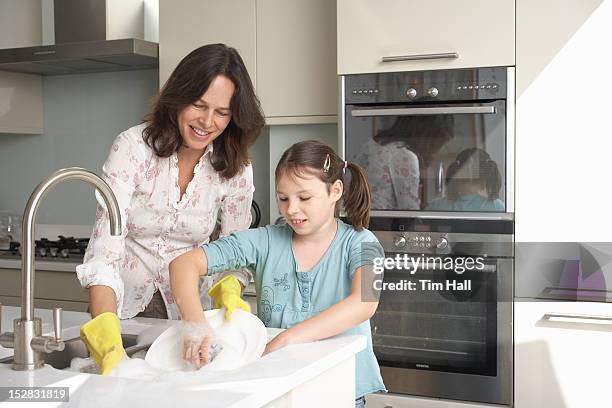 mother and daughter washing dishes - doing household chores stock pictures, royalty-free photos & images