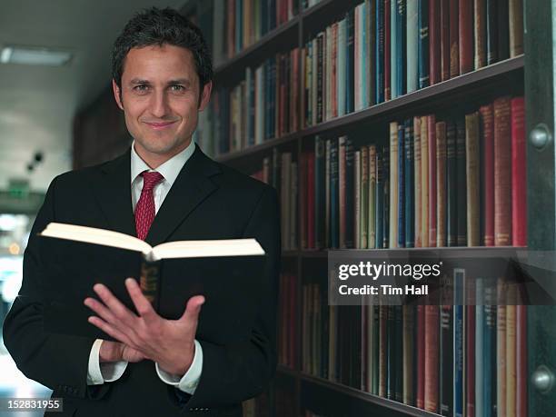 empresario leyendo libro en la biblioteca - law books fotografías e imágenes de stock