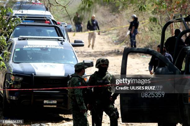 Members of the Mexican Army work at the site of an explosive attack against a police patrol in Tlajomulco de Zuñiga, a suburb at the city of...