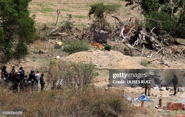 Forensic employees work at the site of an explosive attack against a police patrol in Tlajomulco de Zuñiga, a suburb at the city of Guadalajara,...