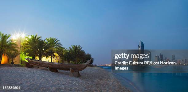 canoe on sand at urban beach - abu dhabi beach stock-fotos und bilder