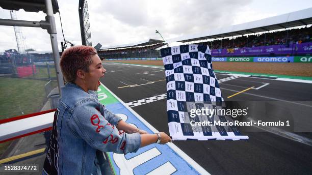 Florence Pugh waves the chequered flag during the F1 Grand Prix of Great Britain at Silverstone Circuit on July 09, 2023 in Northampton, England.