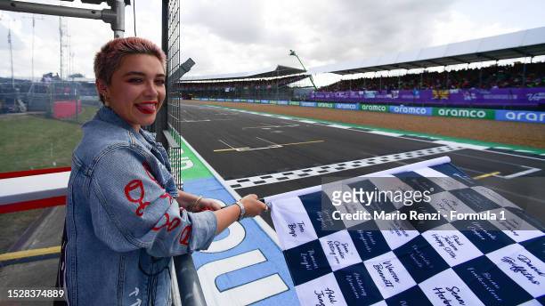 Florence Pugh poses with the chequered flag during the F1 Grand Prix of Great Britain at Silverstone Circuit on July 09, 2023 in Northampton, England.