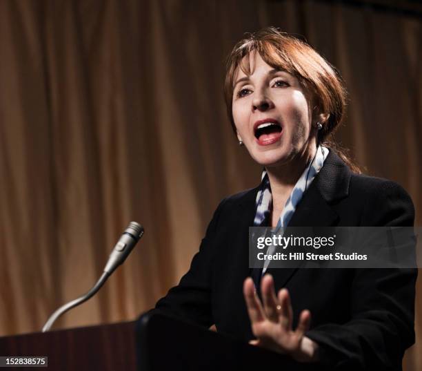 caucasian businesswoman speaking at podium - microphone mouth stock-fotos und bilder