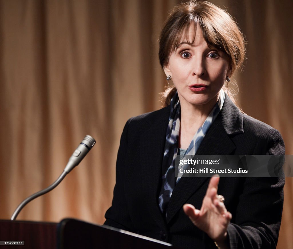 Caucasian businesswoman speaking at podium