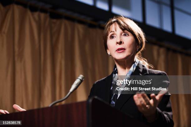 caucasian businesswoman speaking at podium - uomo politico foto e immagini stock