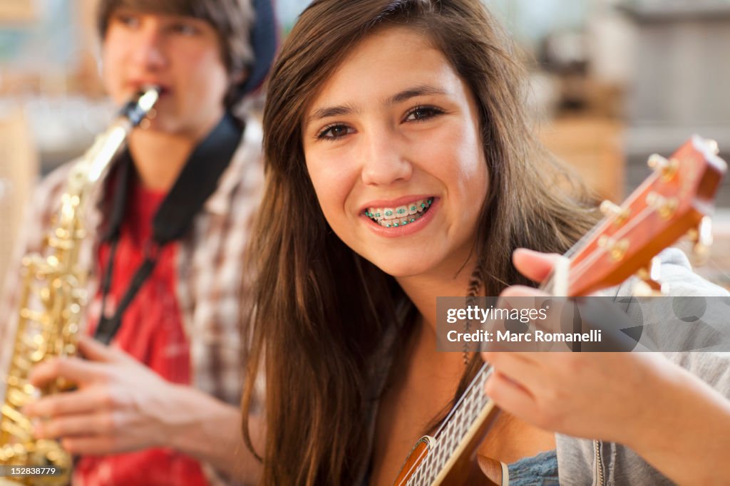 Mixed race girl playing guitar