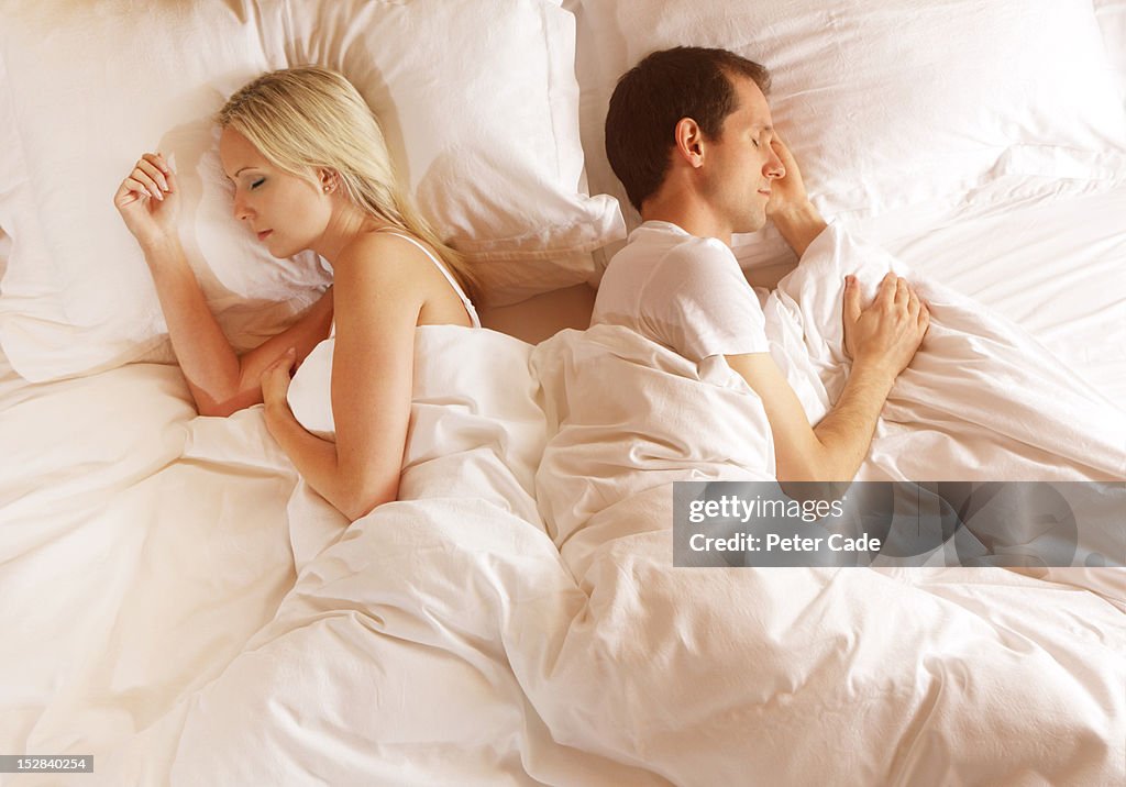 Couple in bed back to back