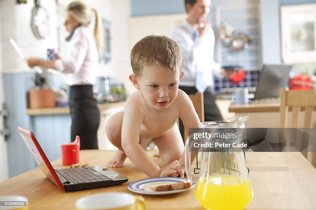 Toddler on table, distracted working parents