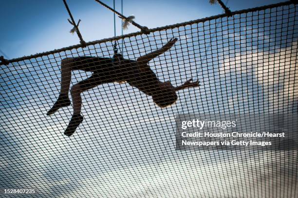 Corbin Adkins of Houston lets go of the trapeze to be catch by the safety net during a trapeze class at Trapeze Texas in Houston, Thursday, May 28,...