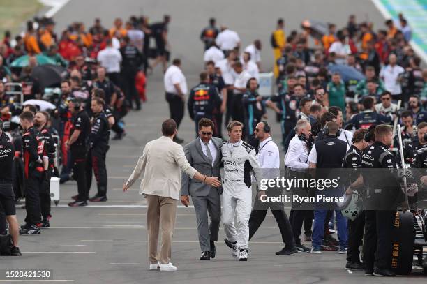 Brad Pitt, star of the upcoming Formula One based movie, Apex, and Javier Bardem talk on the grid during the F1 Grand Prix of Great Britain at...