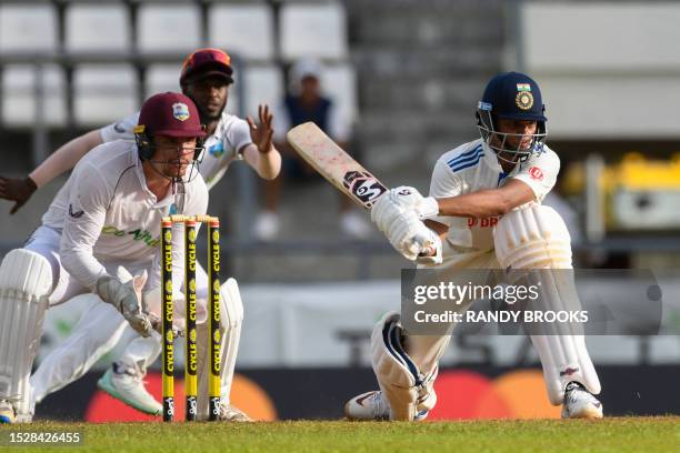 Yashasvi Jaiswal of India sweeps as Joshua Da Silva of West Indies watches during the 1st day of the 1st Test between West Indies and India at...