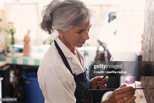 a female painter in her studio - woman painting stock pictures, royalty-free photos & images