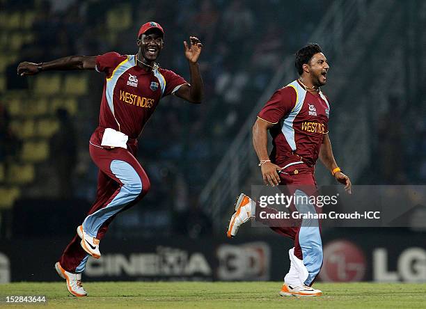 Darren Sammy and Ravi Rampaul of West Indies celebrate the wicket of Luke Wright of England during the A1 versus B2 Super Eight match between England...