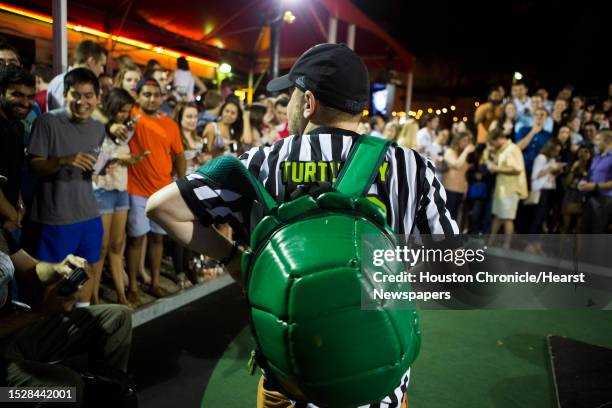 Nick Menage the "Turtle Guy" puts on his turtle shell backpack to start the turtle races at Little Woodrow's in 2306 Brazos Street, Thursday, May 21...