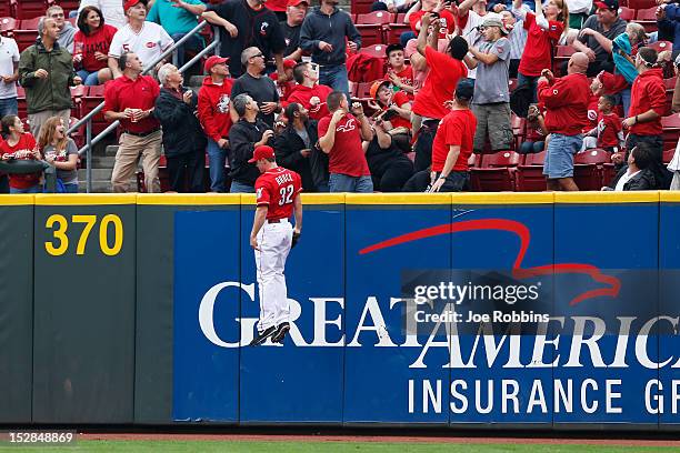 Jay Bruce of the Cincinnati Reds reacts after not being able to catch a home run hit by Carlos Gomez of the Milwaukee Brewers in the third inning of...