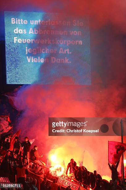 Fans of Kaiserslautern throw smoke bombs during the Second Bundesliga match betweeen VfL Bochum and 1. FC Kaiserslautern at Rewirpower Stadium on...