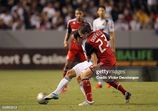 Landon Donovan of the Los Angeles Galaxy holds off a challenge from Terry Dunfield of Toronto FC during the MLS match at The Home Depot Center on...